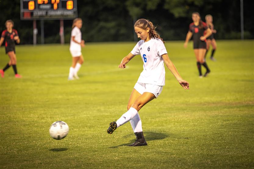A soccer player kicks the ball